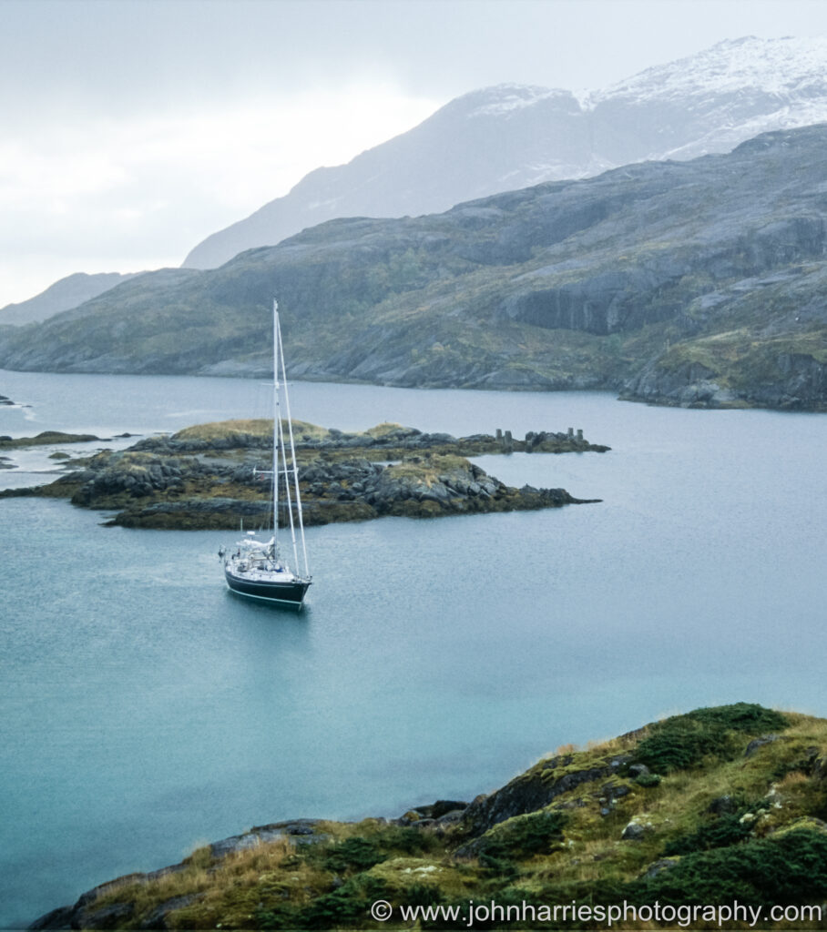 A sailing yacht anchored in a small anchorage using two anchorages to minimise swinging room